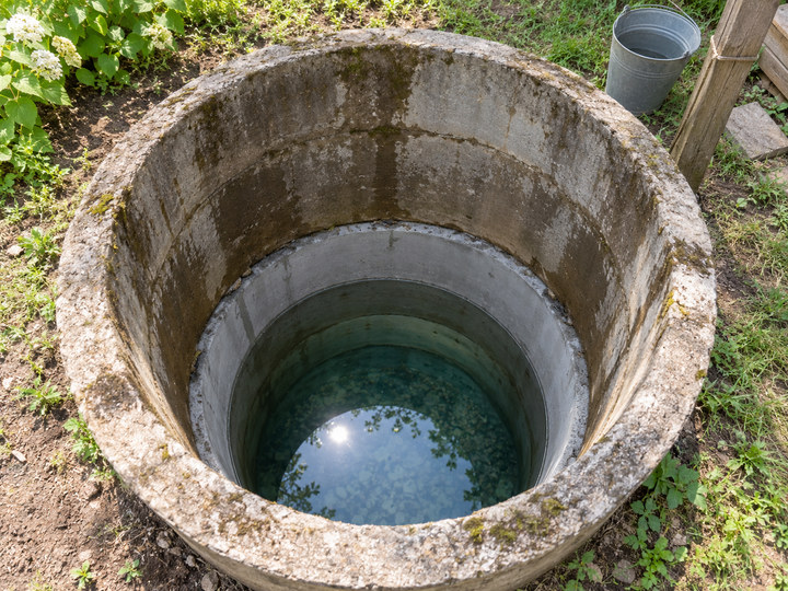 Ремонтное кольцо внизу старого колодца, чистая вода